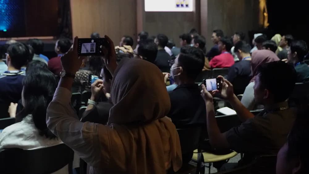 Attendees photographing a session slide at SCALECON Jakarta 2025