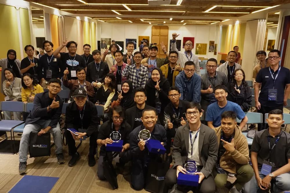The workshop room together for a group photo, award winners holding their trophies at the front, at SCALECON Jakarta 2025
