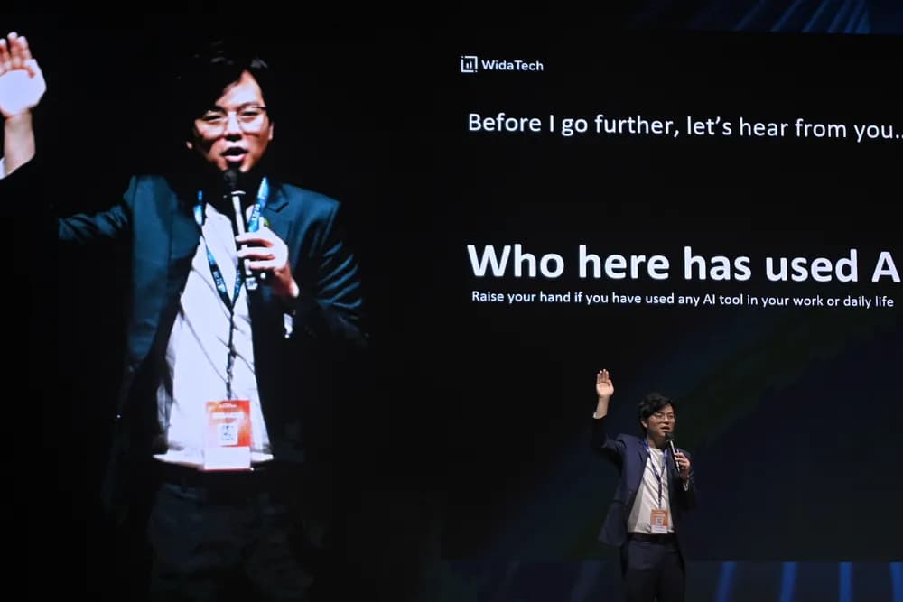 A speaker asking the room who has used AI at work, at SCALECON Surabaya 2026